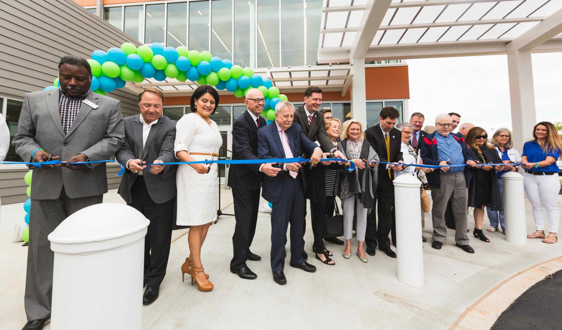 A group of elected officials cutting a ribbon at a senior health and wellness center.