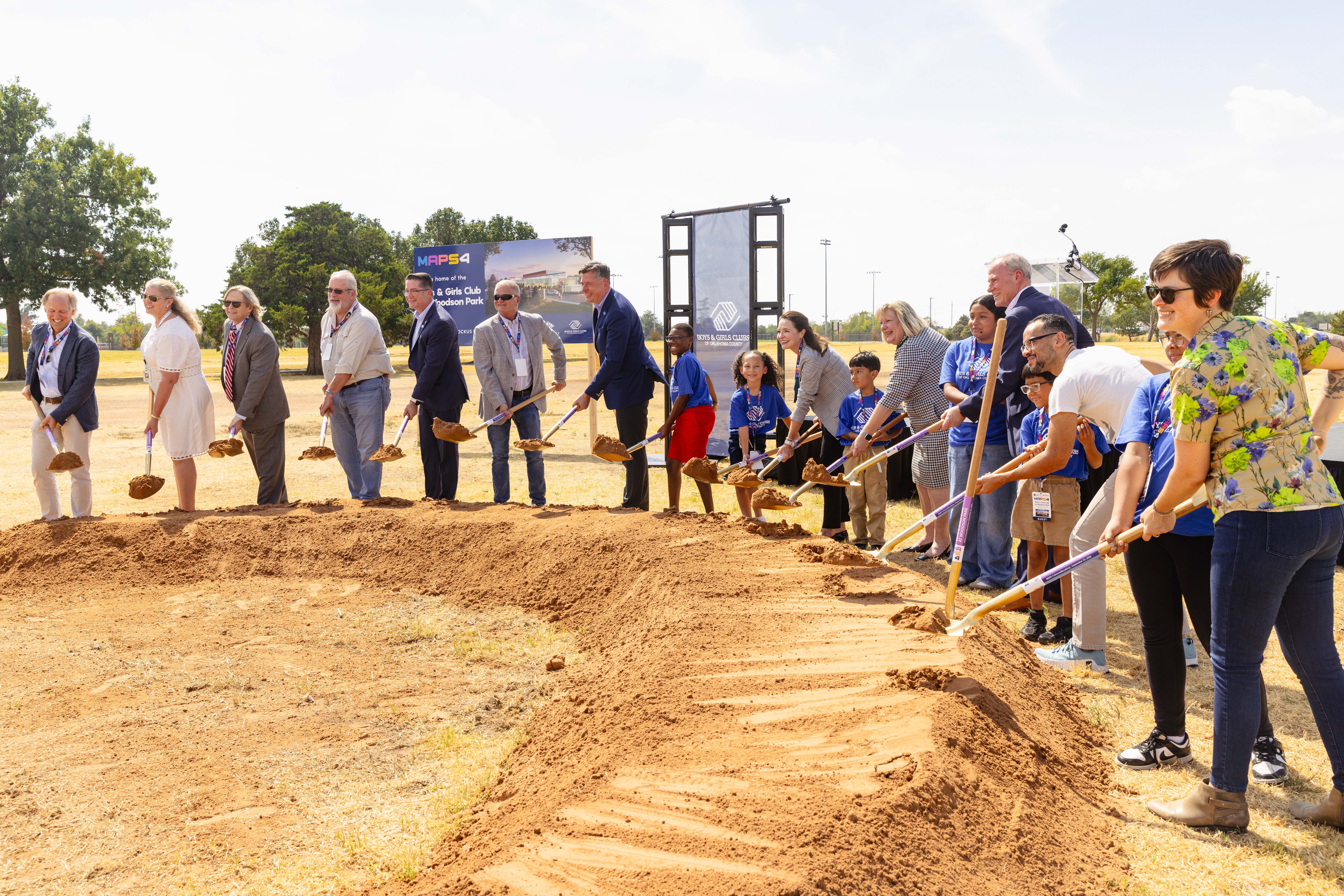 city leaders and boys and girls club kids turning dirt during groundbreaking