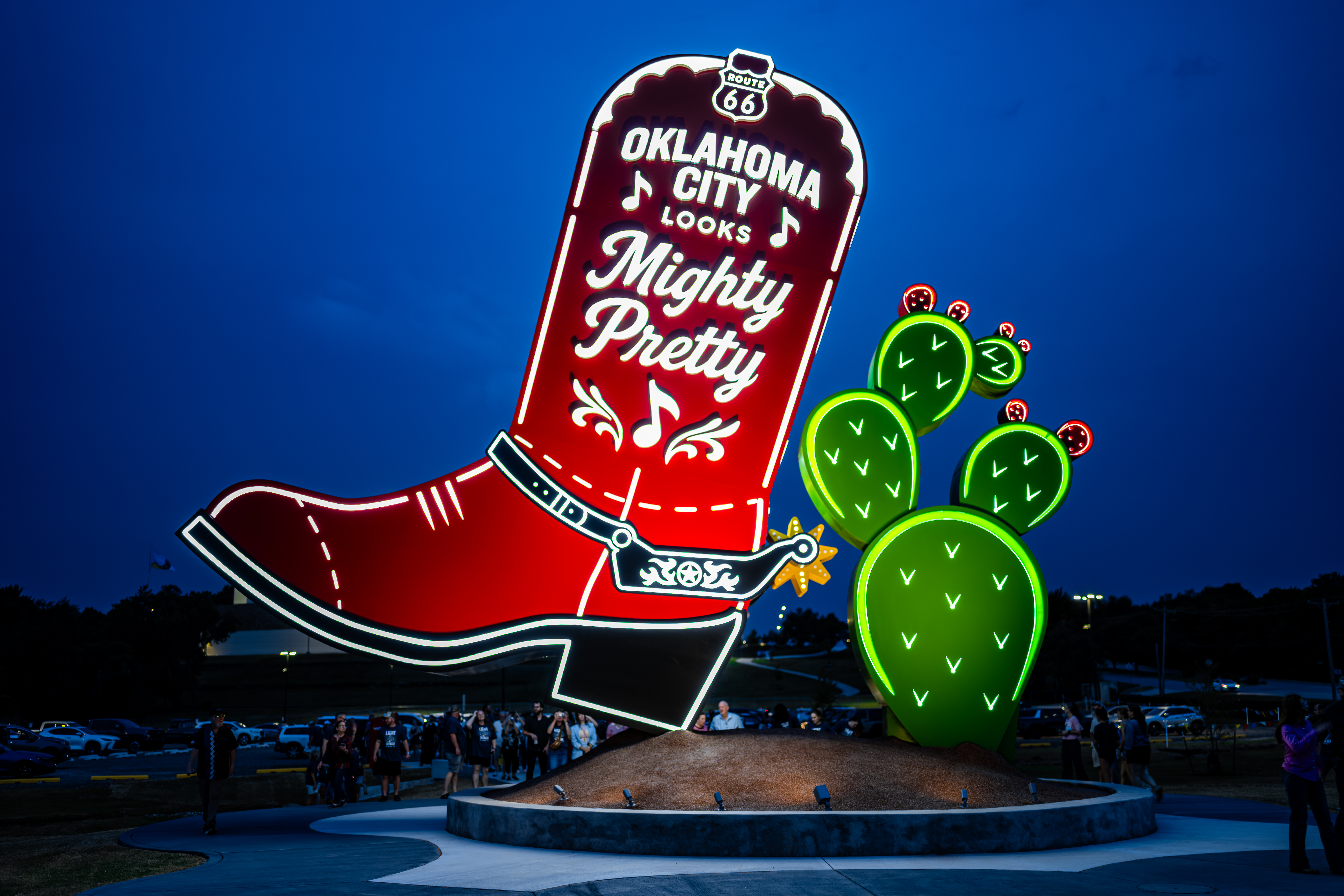 massive red boot sculpture lit up at night