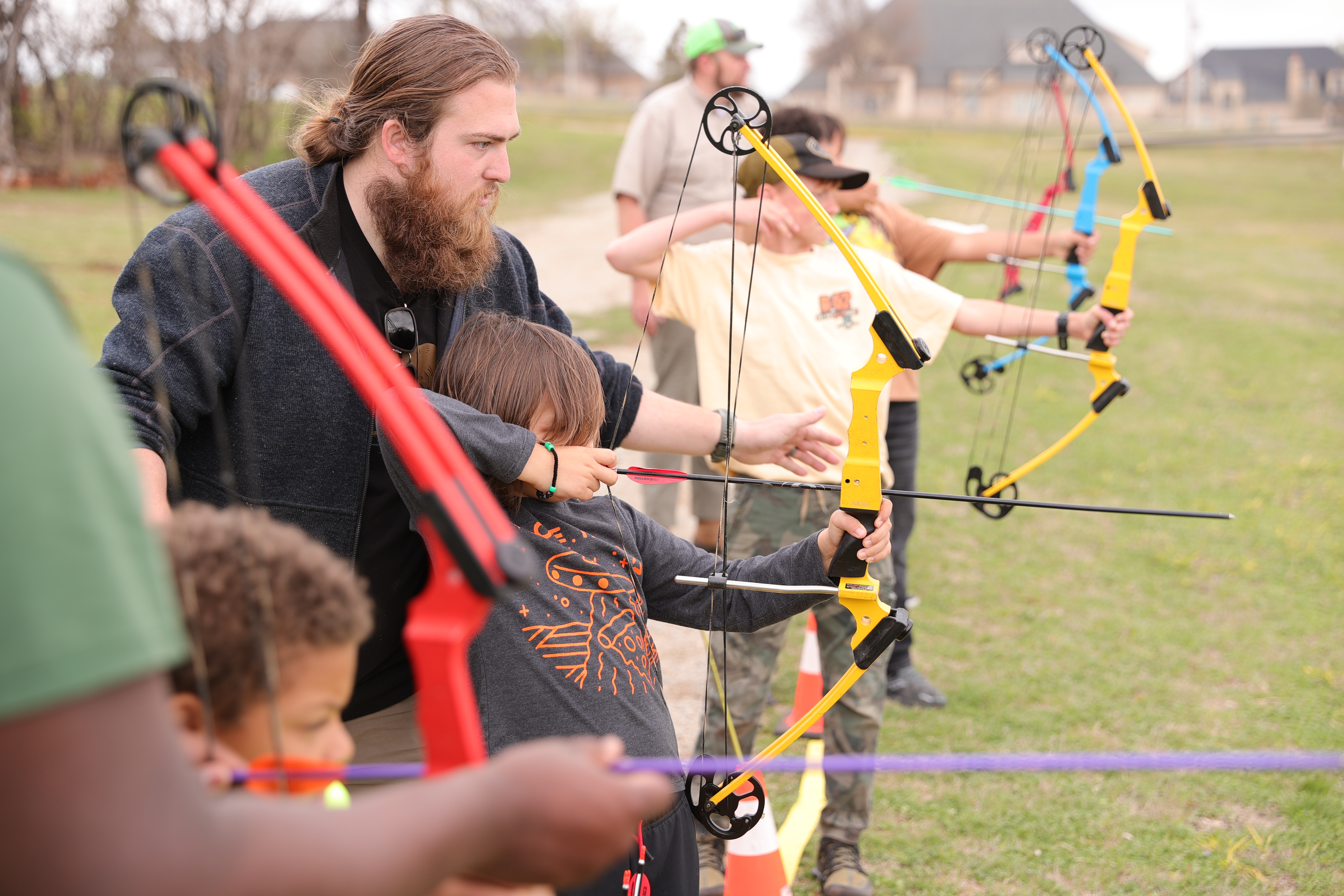 kids learning archery with instructors