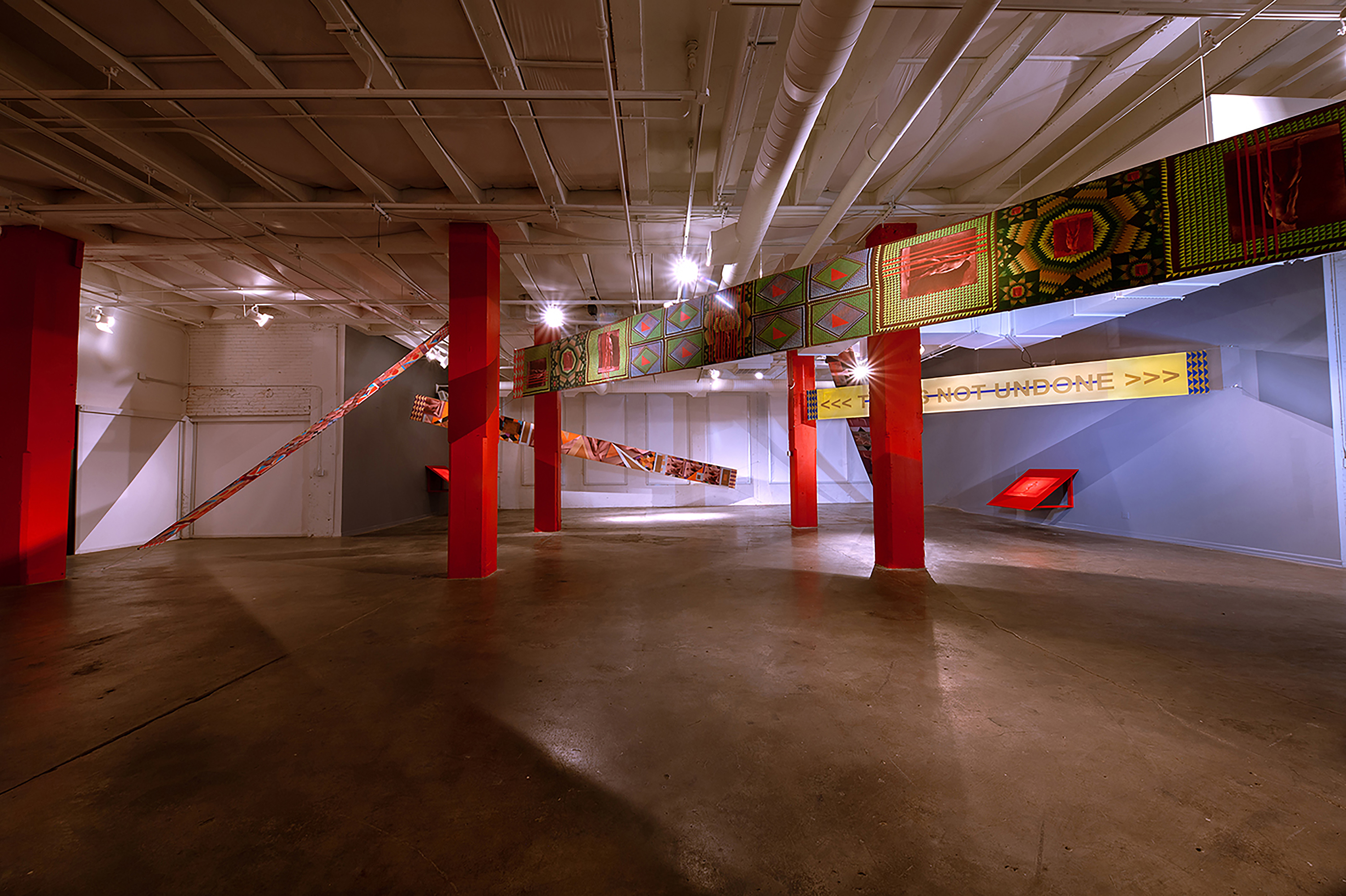 large room with concrete floors with color banners across the ceiling