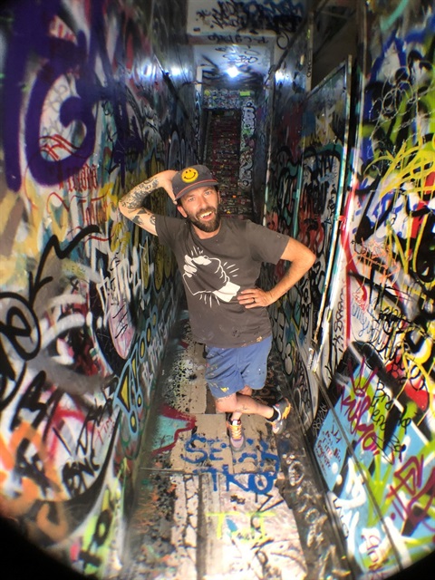 guy posing in graffiti hallway