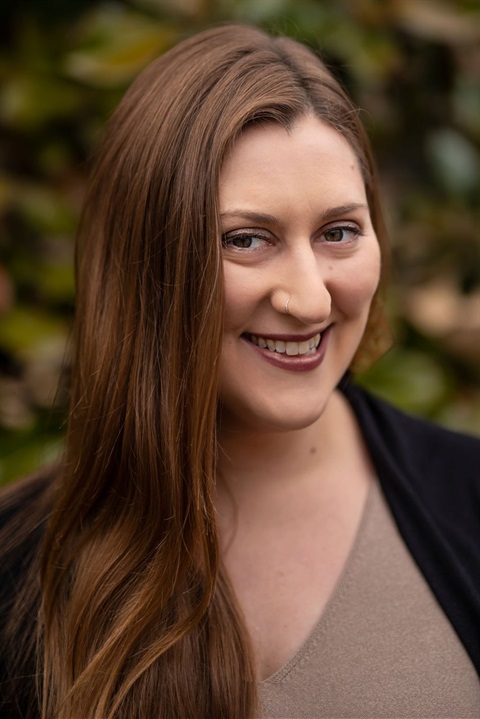 woman smiling at camera with long brown hair