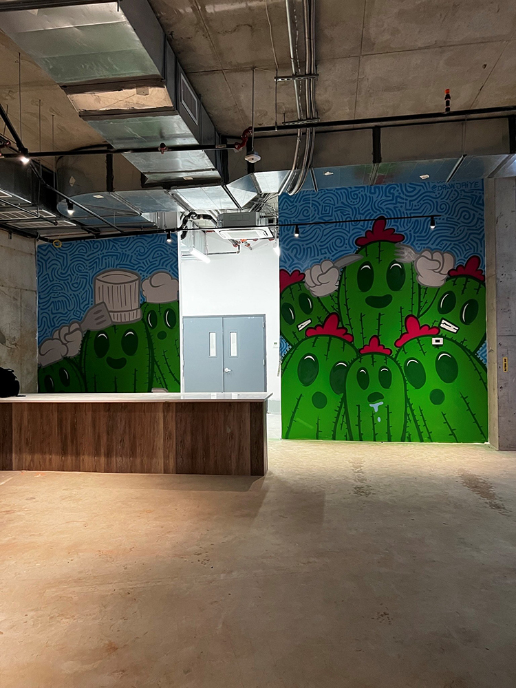 two murals split by doors of cacti with faces