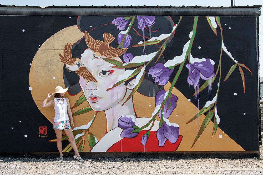 woman posing in front of mural