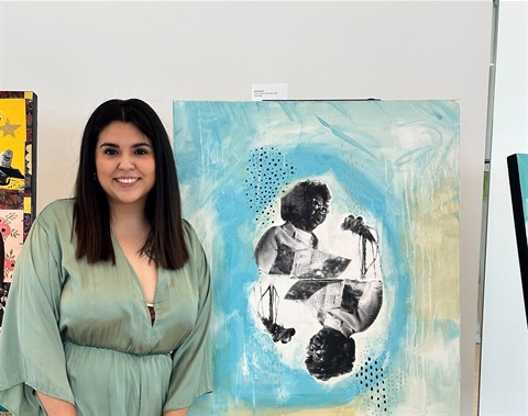 younger hispanic woman in blue blouse next to artwork of Clara Luper