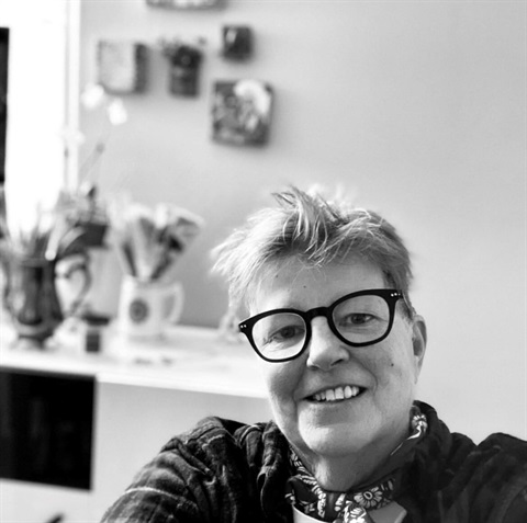 black and white photo of woman wearing bandana and thick rimmed glasses