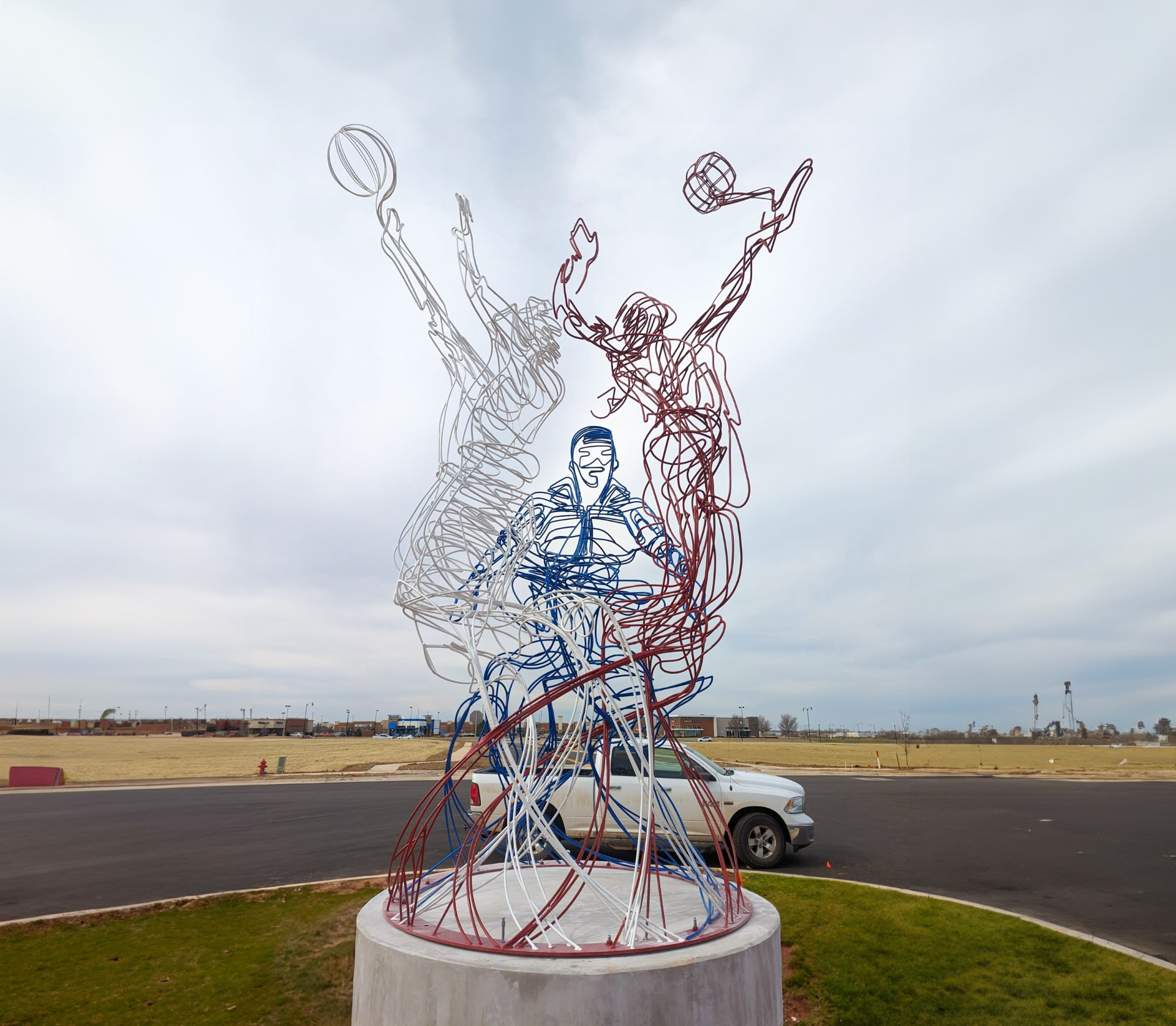 steel sculpture with three people playing sports
