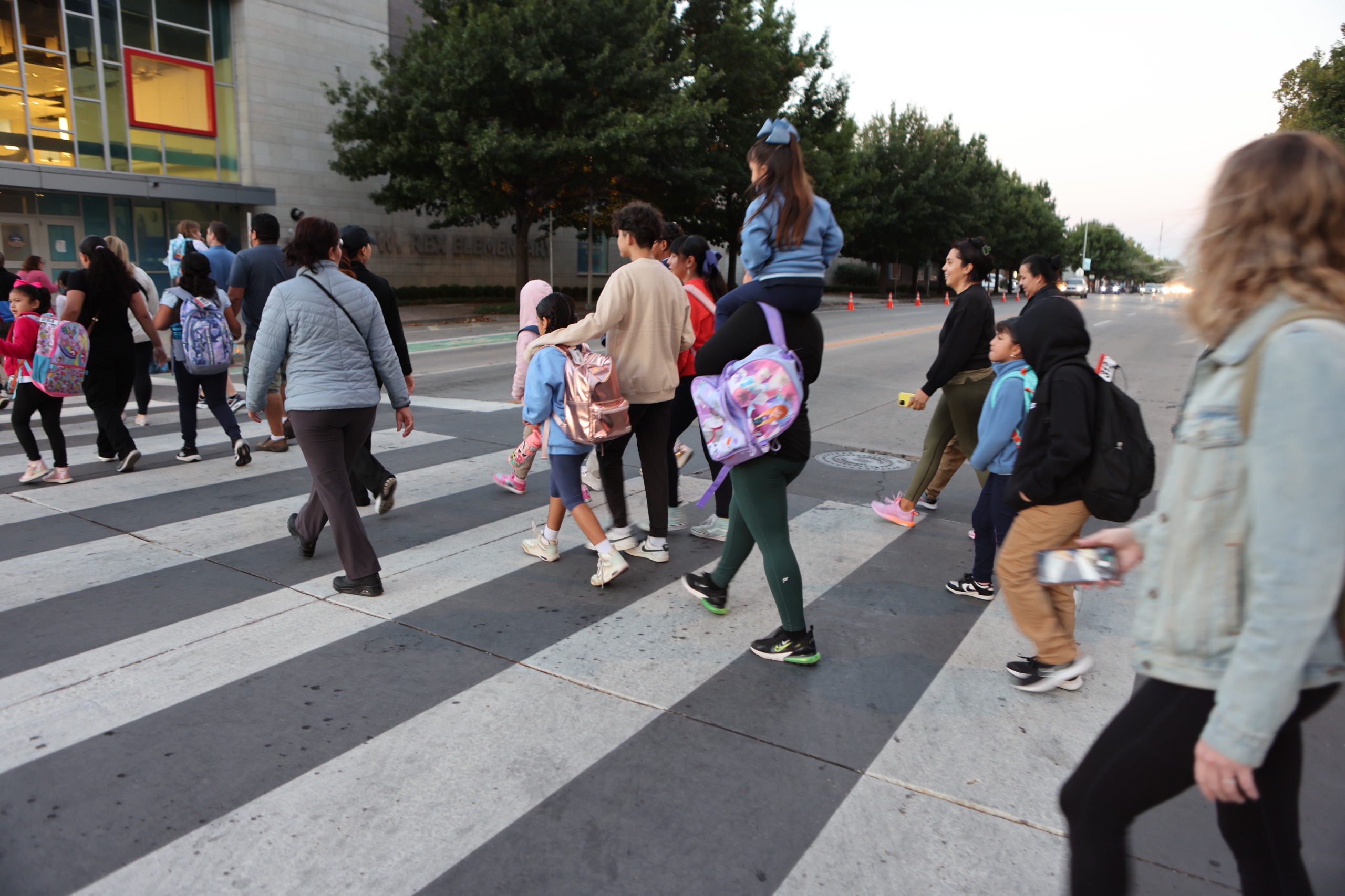 kids and parents walking to school on crosswalk