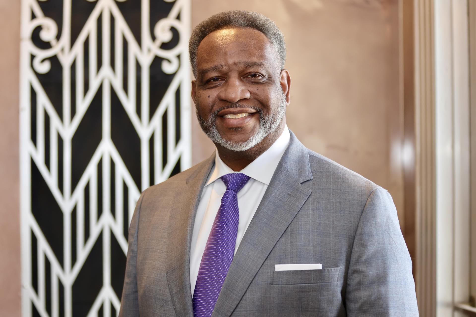 kenneth-morgan smiling wearing gray suit with purple tie