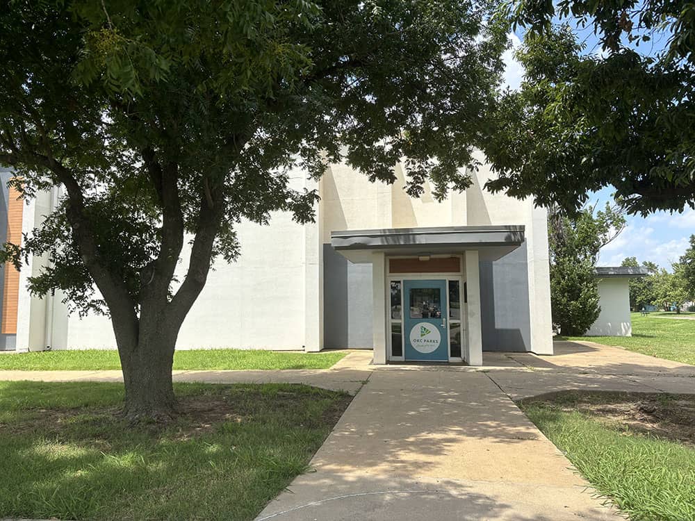 The front door of Woodson Gym surrounded by trees.