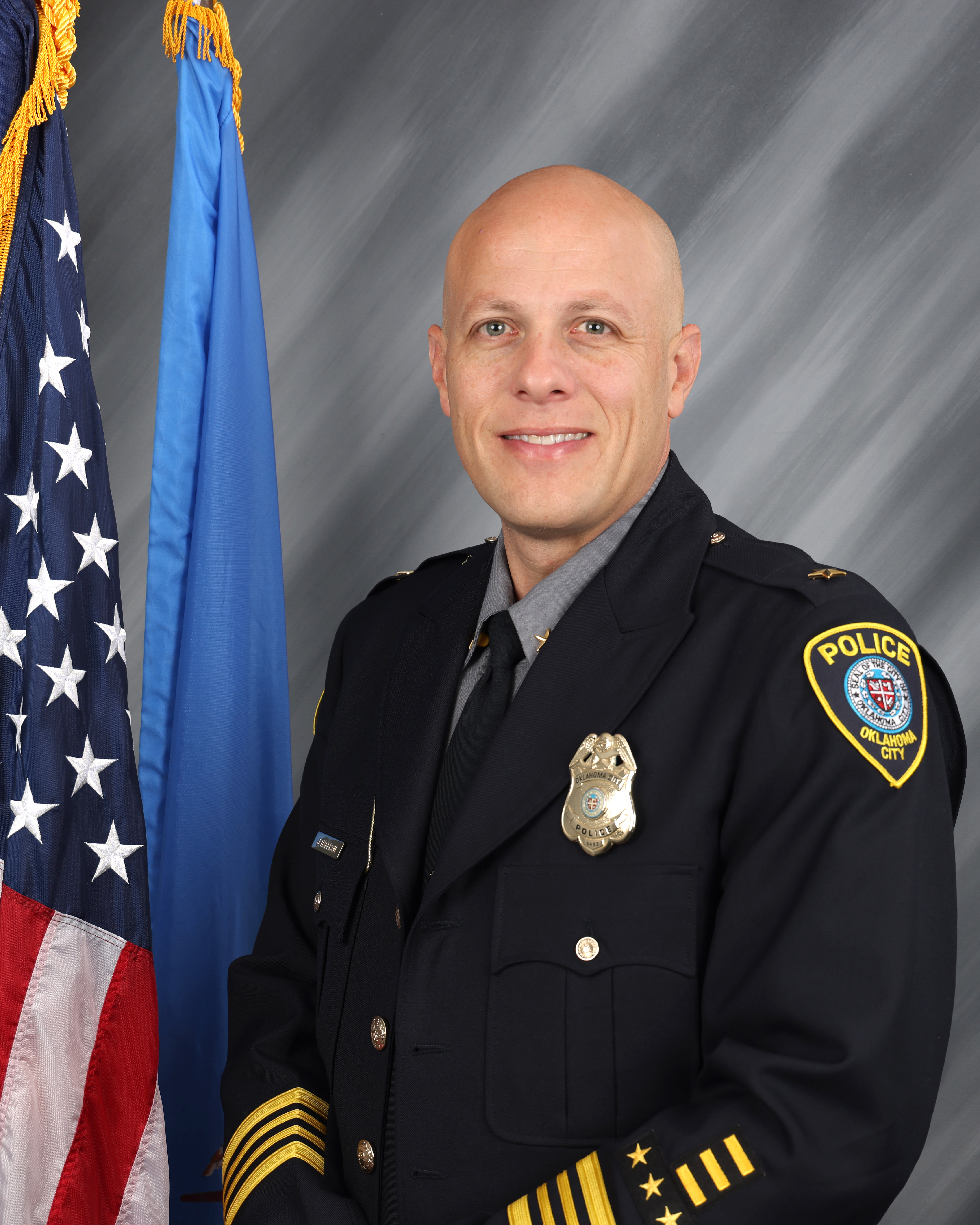 headshot of Deputy Chief Harrison in formal police uniform in front of American flag