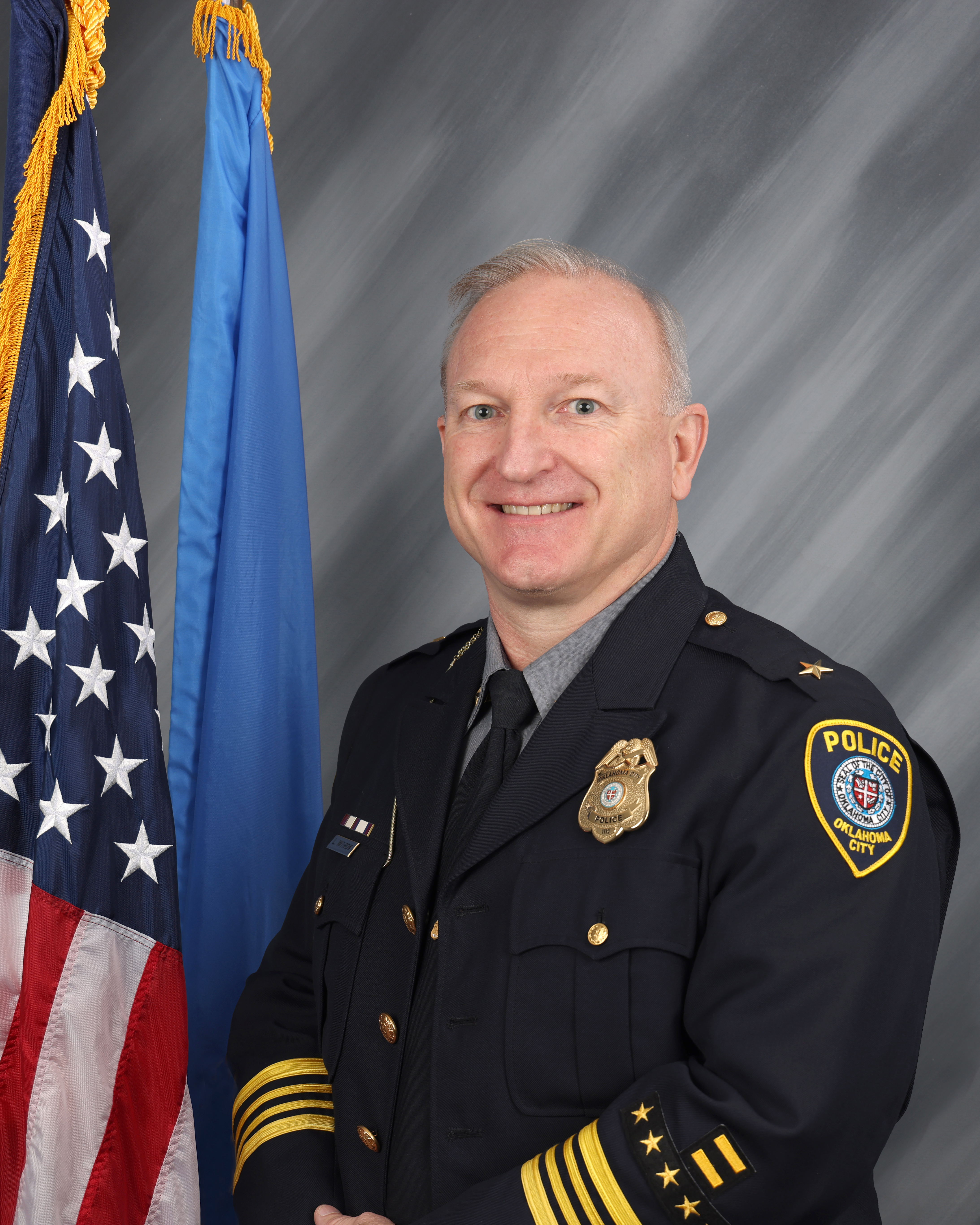 headshot of Deputy Chief Withrow in formal police uniform in front of American flag
